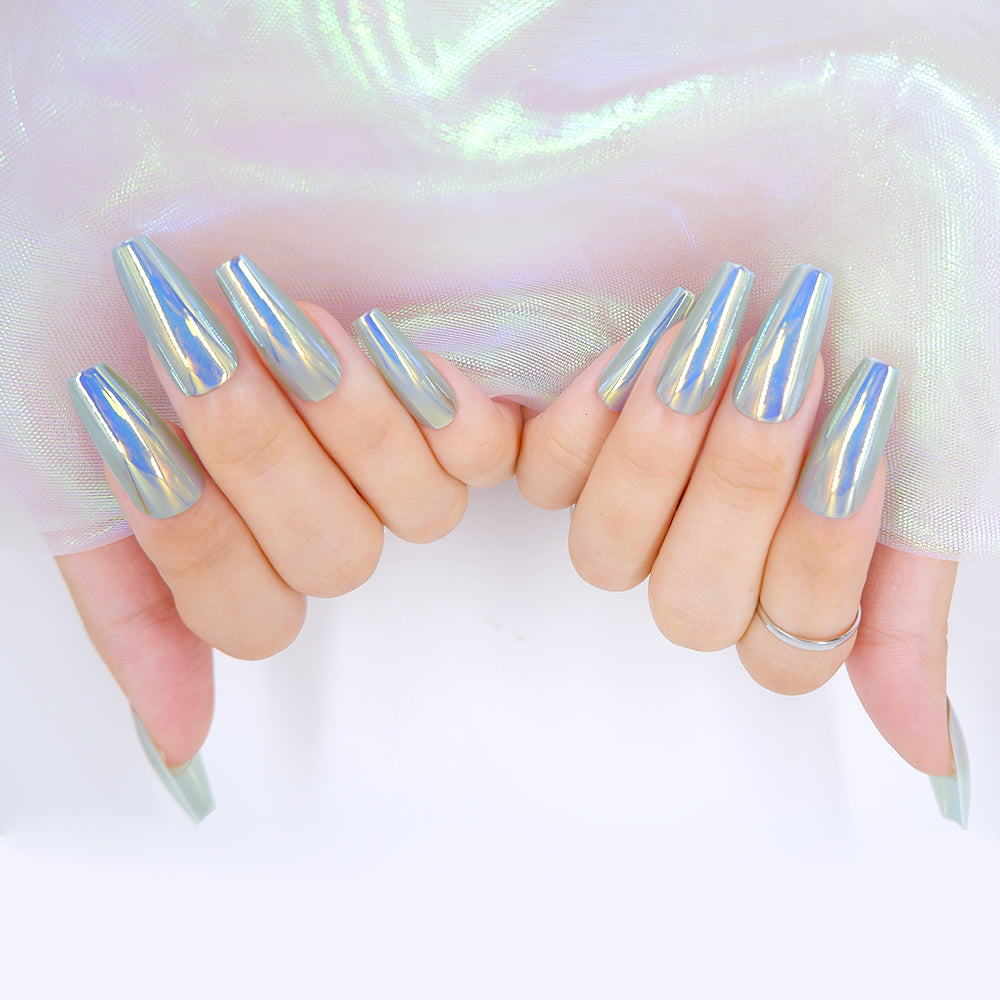 Fingers adorned in long coffin shaped press on nails, in a blue chrome color, holding a white fabric.